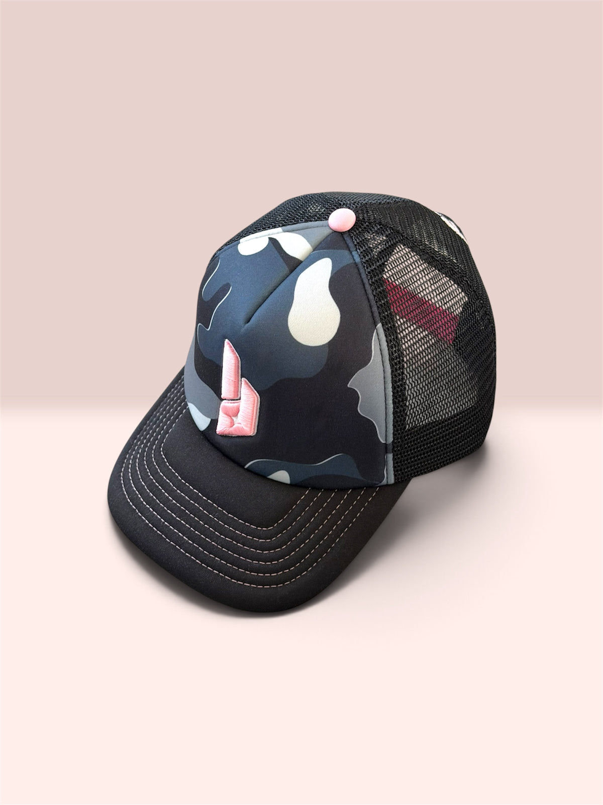 Lunad grey black and white camo front with pink embroidered logo and pink stitching on brim. Black mesh and pink solid button.